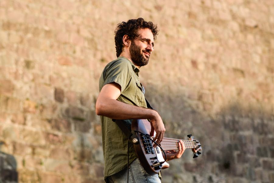 Martín Laportilla tocando el bajo al aire libre